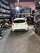 Beyaz Ford Fiesta Dükkan İçinde Lastik Montajı